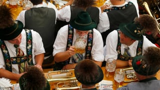 Männer in Trachten an einem Tisch, sie trinken Bier.