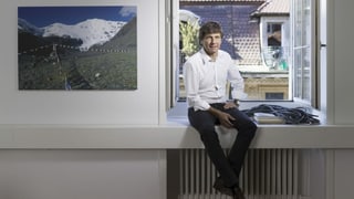 Andre Lüthi sitzt in seinem Büro auf dem Fenstersims und blickt in die Kamera. Andre Lüthi sitzt in seinem Büro auf dem Fenstersims und blickt in die Kamera.