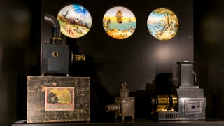 Zwei dia-ähnliche Projektoren, im Hintergrund runde Bilder