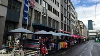 Blick auf einen Laden an der Clarastrasse, es hat Kleiderständer auf dem Trottoir