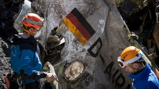 Zwei Männer und ein Trümmerteil der abgestürzten Germanwings-Maschine.