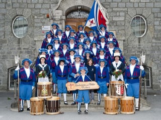 Die Pfeifer und Trommler in blauen Uniformen haben sich auf eine Treppe fürs Foto gruppiert.