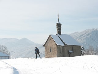 Langläufer vor Kapelle.