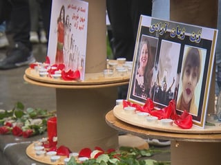 Bilder der verstorbenen Amini, umringt von Kerzen und Blumen.