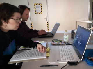 Zwei Personen vor Laptops.