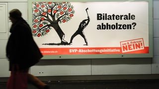 Person geht an einem Abstimmungsplakat vorbei. Person geht an einem Abstimmungsplakat vorbei.