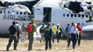 Experten nähern sich einem Flugzeugwrack.