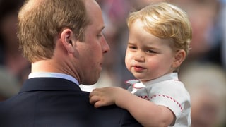 Prinz George wird von Papa William getragen.