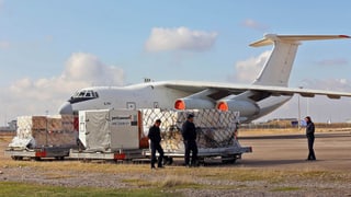 Hilfsgüter auf dem Rollfeld stehen bereit, um in ein Flugzeug eingeladen zu werden.