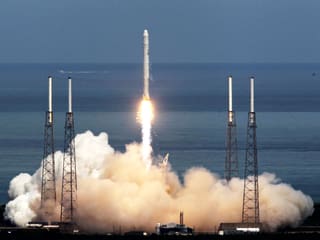 Eine SpaceX-Rakete kurz nach dem Start, am Boden grosse Rauchwolke