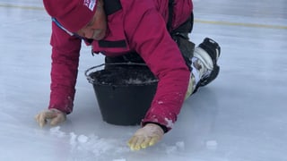 Mit Schneematsch bessert Louis Schönbächler Risse im Eis aus.