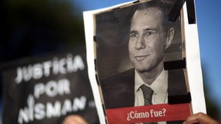 Eine Hand hält ein Foto Nismans in die Höhe.