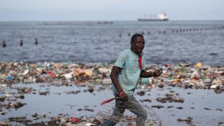 Mann vor Plastik-Müllbergen. Mann vor Plastik-Müllbergen.