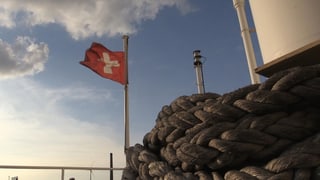 Schweizer Flagge und Taue auf Frachtschiff.