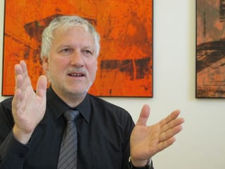 Mann mit schwarzem Hemd vor rotem Bild