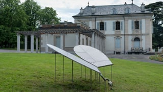 Vor einem historischen Gebäude steht eine Brunnen-Installation.