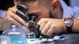 Uhrmacherlehrling montiert eine Uhr Uhrmacherlehrling montiert eine Uhr