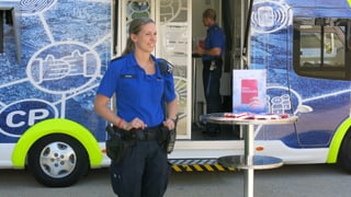 Polizistin steht vor dem Infomobil der Basler Polizei.