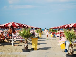 Symmetrisch aneinandergereihte Sonnenschirme am Strand von Rimini.