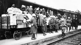 Mehrere Soldaten vor einem Zug auf einer historischen Aufnahme