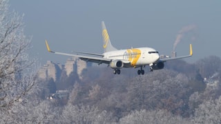 Flugzeug im Landeanflug, im Hintergrund Wohnblöcke Flugzeug im Landeanflug, im Hintergrund Wohnblöcke