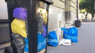 Abfallcontainer gefüllt mit farbigen Säcken