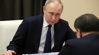 Putin in einem Gespräch an einem Tisch