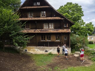 Ein altes Haus in Zug, vier Personen stehen davor im Garten. Ein altes Haus in Zug, vier Personen stehen davor im Garten.