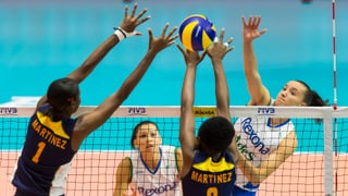 Eine Brasilianerin durchbricht einen doppelten Block von zwei Spielerinnen von Santo Domingo.