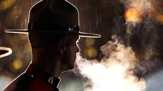 Kanadischer Mounty-Polizist im Gegenlicht fotografiert. Aus seiner Nase strömt eine Atemdampfwolke.