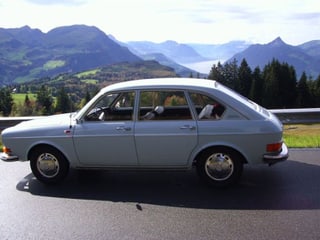 Ein älterer aber noch fitter Wagen auf einer Bergstrasse.