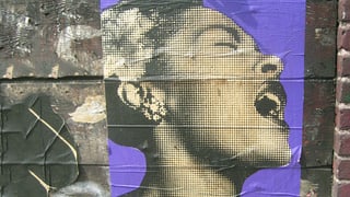Plakat auf einer Mauer. Es zeigt Billie Holiday, wie sie mit expressivem Gesichtsausdruck singt. 