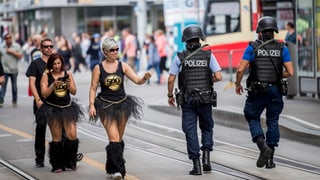 Zwei Frauen grüssen zwei Polizisten.