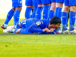 Carles Alena liegt am Boden hinter der Mauer