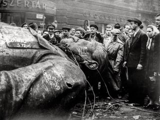 Schwarz-weiss-Bild: Ungarer betrachten die gefallene Stalin-Statue.