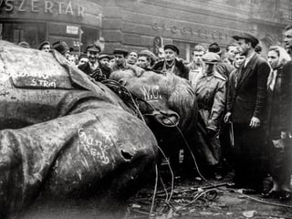 Schwarz-weiss-Bild: Ungarer betrachten die gefallene Stalin-Statue. Schwarz-weiss-Bild: Ungarer betrachten die gefallene Stalin-Statue.