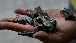 In einer Hand liegen Bruchstücke einer Munition