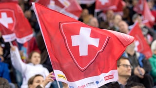 Schweizer Fans schwenken eine rote Fahne mit weissem Kreuz.