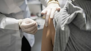 Arzt sticht Impfung in Arm
