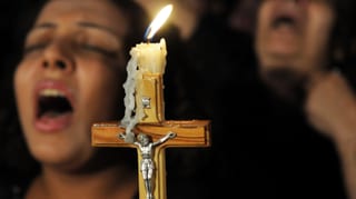 Singende koptische Christen halten ein Kreuz in der Hand. Singende koptische Christen halten ein Kreuz in der Hand.