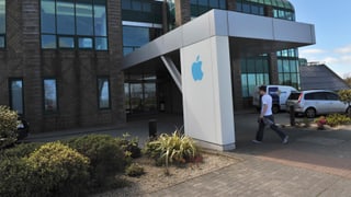 Ein Mann geht in ein Unternehmensgebäude von Apple in Irland.