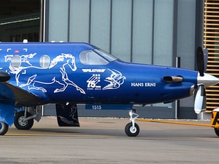 Ein blaues Flugzeug mit weisser Schrift verziert.