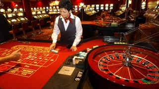 Eine Croupier im Grand Casino in Basel vor einem fast leeren Tisch.