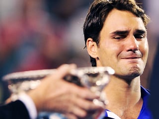 Ein Pokal wird überreicht. Federer schielt darauf und verzieht sein Gesicht.