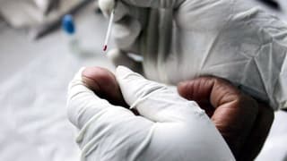 Einem Patienten wird am Finger ein wenig Blut abgenommen. 
