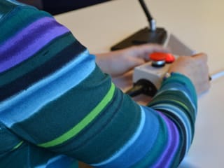 Zwei Hände links und rechts des Buzzers.