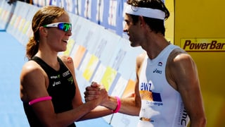 Der Zürcher Sven Riederer noch im weissen Sportoutfit gratuliert der schwarz bekleideten Daniela Ryf direkt hinter der Ziellinie. 