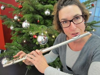 Joelle Beeler mit Querflöte vor dem Weihnachtsbaum.