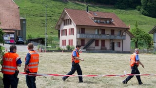 Blick über eine Wiese mit vier Polizisten. Blick über eine Wiese mit vier Polizisten.