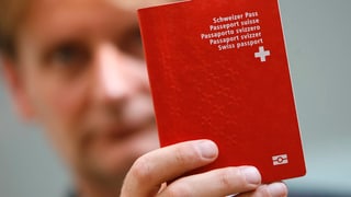 Ein Mann hält einen Schweizer Pass